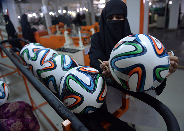 A worker checks a World Cup ball in Sialkot, Pakistan – photo Aamir Qureshi