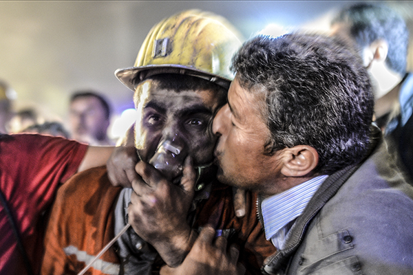 A father kisses his son who has just been rescued from a mine – photo Bulent Kilic