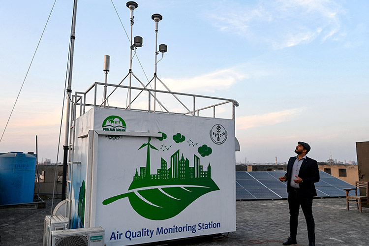 17/02/25 – Lahore, Pakistan– An Anti-Smog Squad (ASS) official looking at an air quality monitoring station installed on the terrace of a university in Lahore.