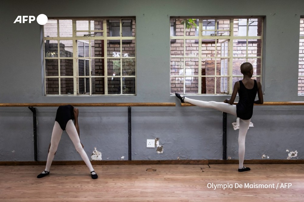 Pupils stretch before a ballet class in Soweto near Johannesburg, on March 20, 2024
