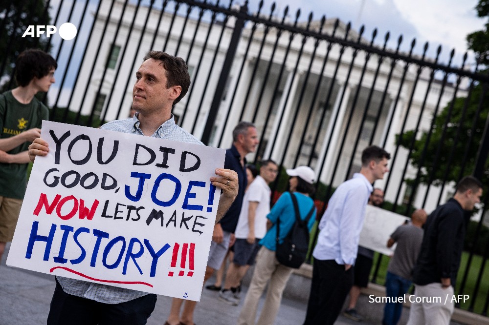 A man holds a sign showing his appreciation for US President Joe Biden along Pennsylvania Avenue in front of the White House in Washington, DC