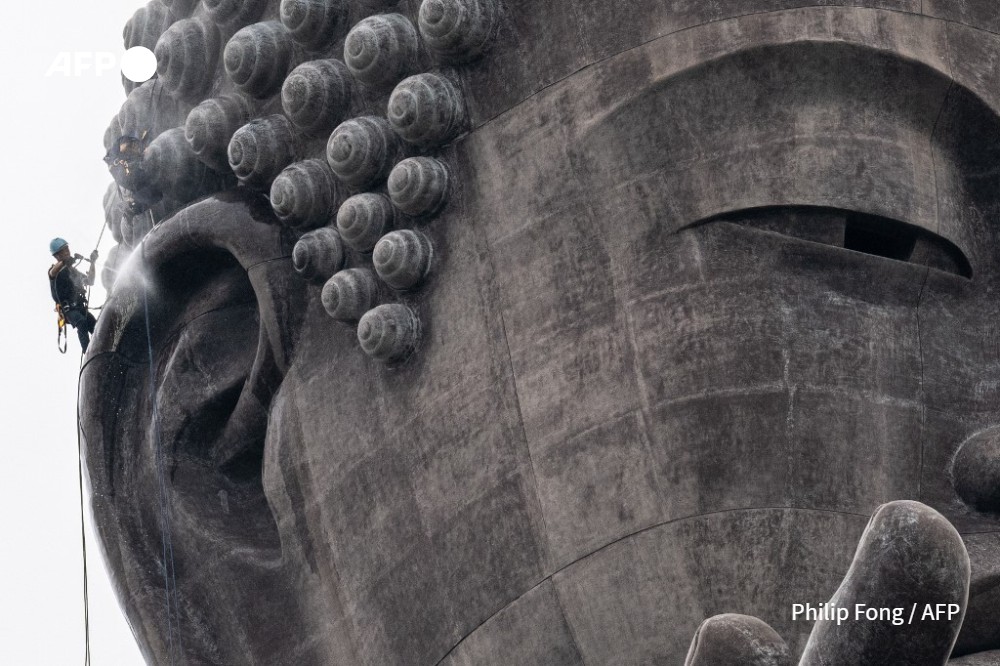 Cleaner Kazuyoshi Taguchi and colleague Kazumi Minowa (not pictured) clean the right ear of the Ushiku Daibutsu giant Buddha statue in Ushiku