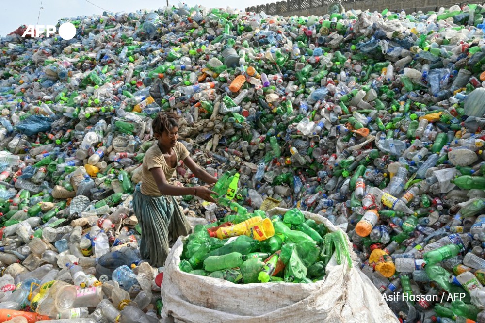A worker sorts used plastic bottles at a recycling unit in Karachi