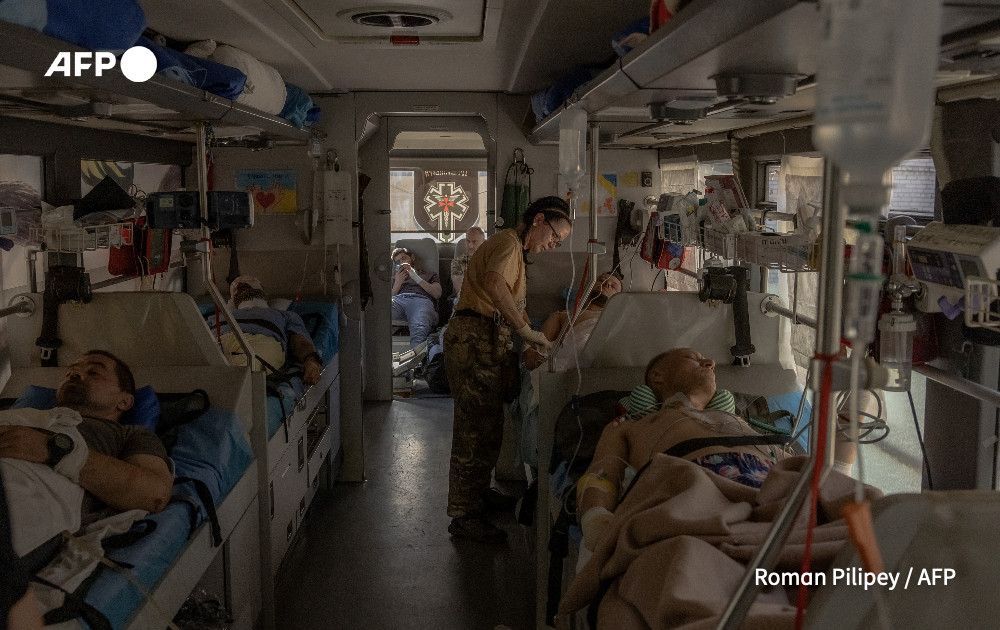 Paramedics of the volunteer medical battalion Hospitallers treat Ukrainian servicemen wounded in fighting in the Donetsk region on a medical evacuation bus driving to a hospital, on October 6, 2024, amid the Russian invasion of Ukraine.