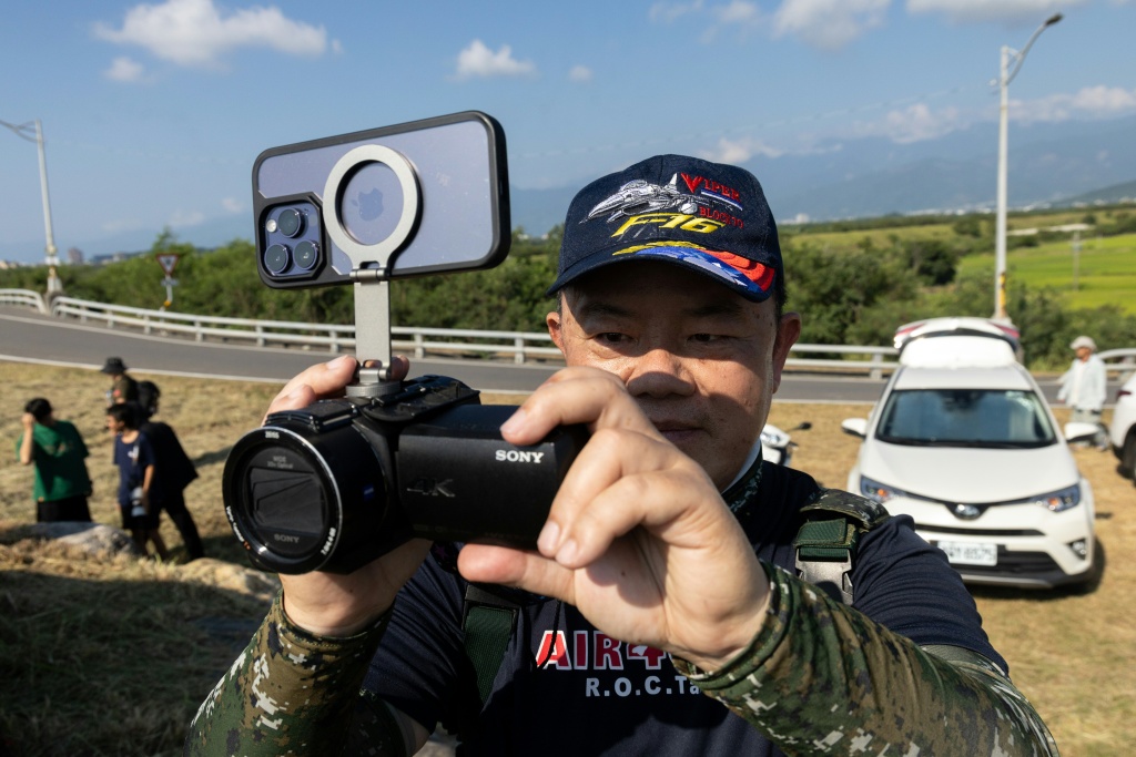 An aviation enthusiast waits outside Chihhang Air Base for the arrival of Taiwan's newly purchased F-16V fighter jets — CHENG Yu-chen / AFP