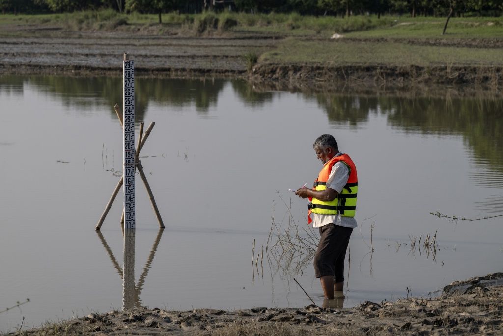 Bangladesh Water Development Board's gauge reader Nazir Uddin recording Padma river's water-level in Ujirpur, near the Bangladesh-India frontier in Bangladesh's Rajshahi division — Salahuddin Ahmed / AFP