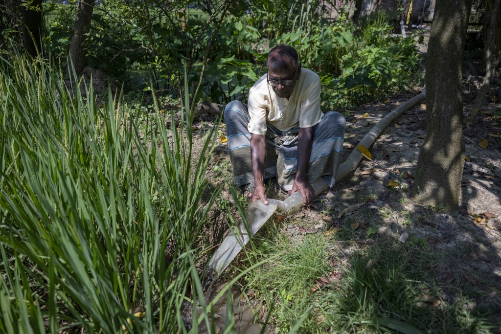 Protestent priest Bikash Soren waters crops at Barind region in Godagari, a drought prone area near the Bangladesh-India frontier — Salahuddin Ahmed / AFP