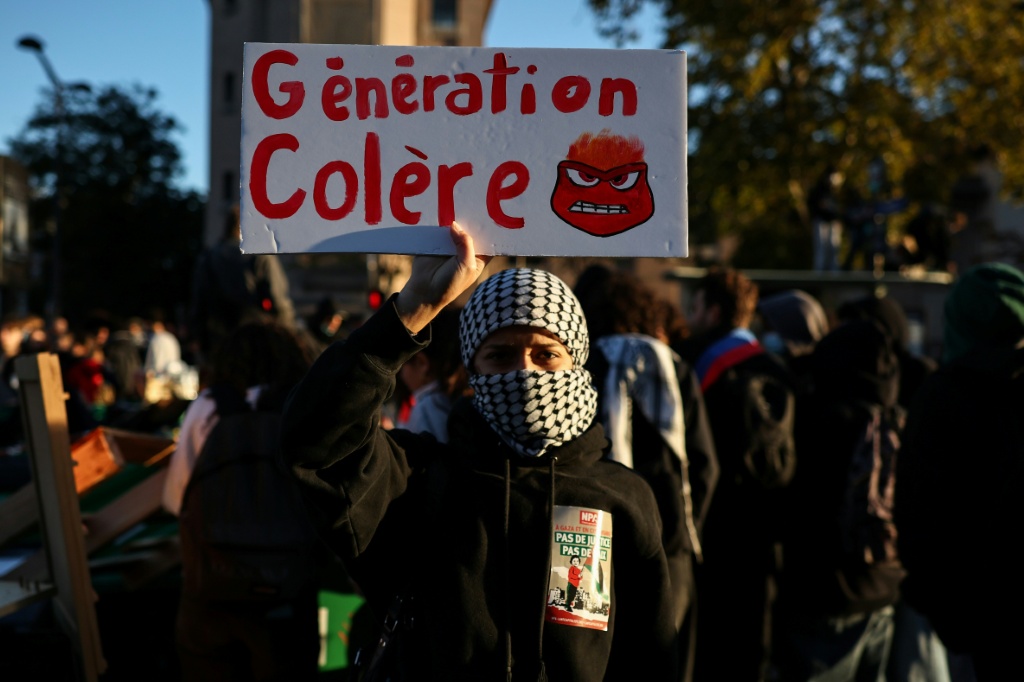 A student holds a sign reading 'Generation Anger' during a school protest in Paris — SIMON WOHLFAHRT / AFP
