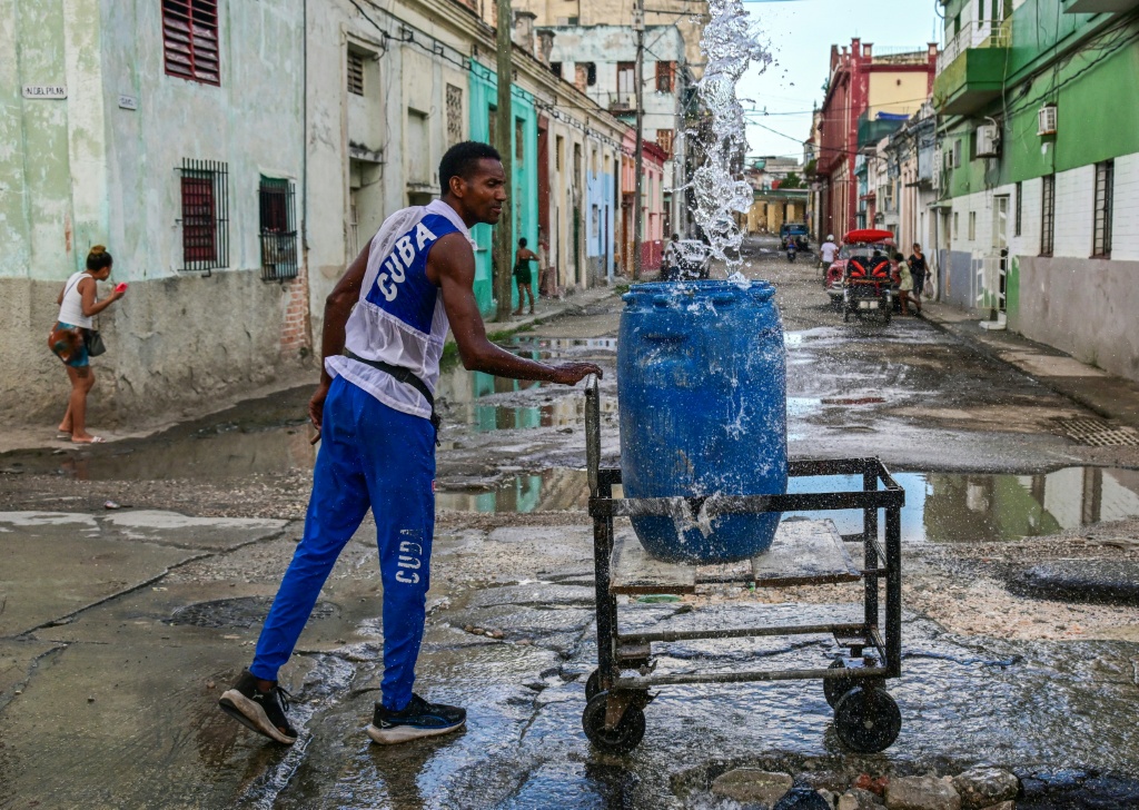 Many Cubans haul water for long distances using all kinds of instruments to transport the resource — YAMIL LAGE / AFP
