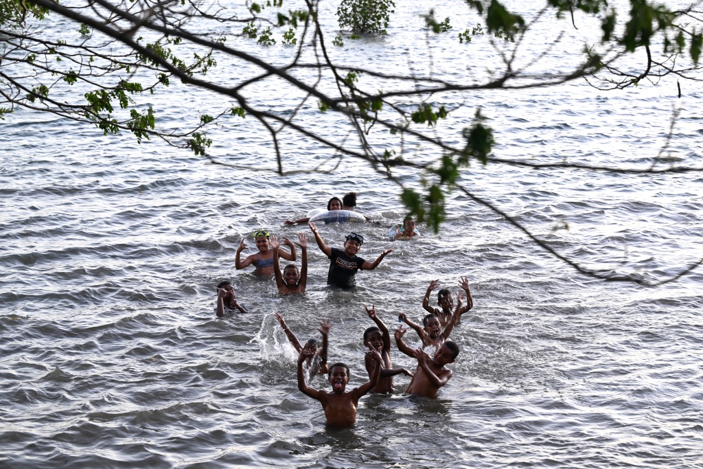 Children swim during high tide off Serua Island in Fiji — Saeed KHAN / AFP