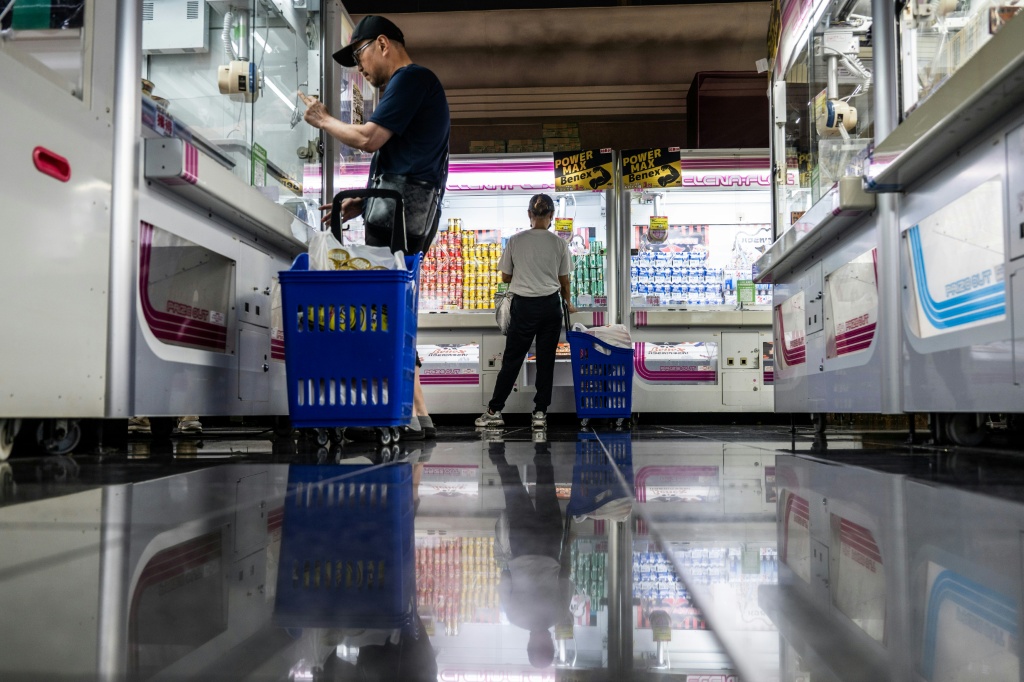 Claw machines were already booming before the inflation wave, but in recent years families in search of everyday items have become a larger part of their clientele. — Andrew CABALLERO-REYNOLDS / AFP