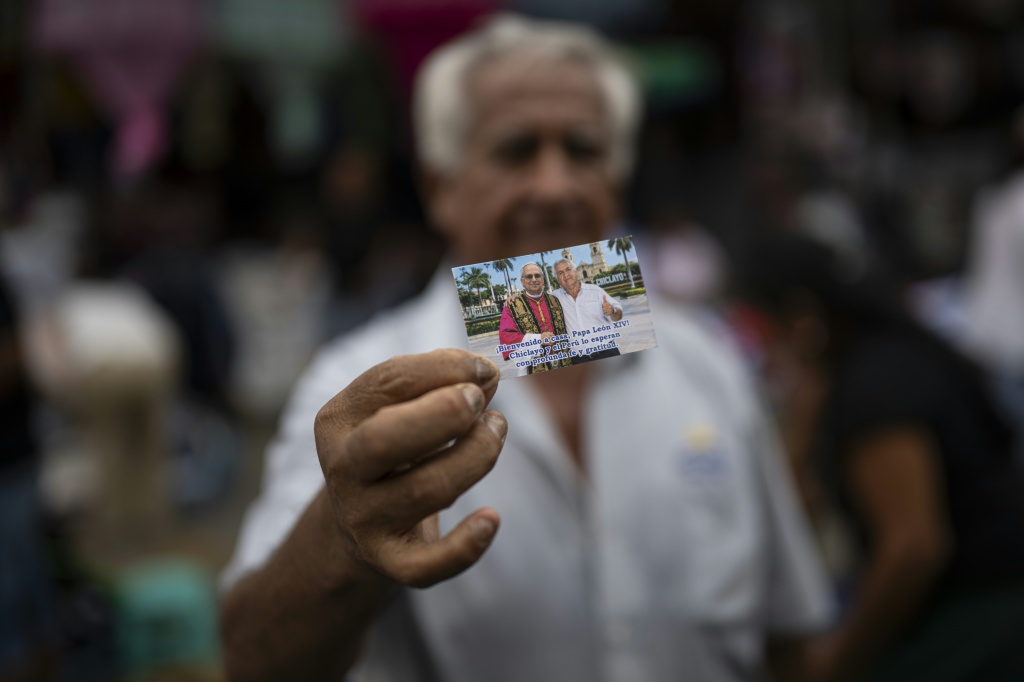 A resident of the Peruvian city of Chiclayo holds up a photo that he claims was taken with Pope Leo XIV before he became pontiff — Ernesto BENAVIDES / AFP