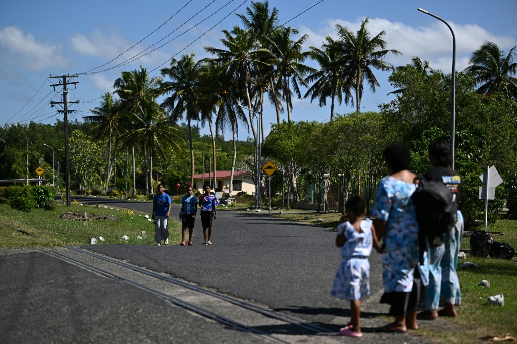 This photo taken on October 9, 2026 shows residents walking along a road in Rukurukulevu village. Government minister Ro Filipe Tuisawau blamed Fiji's rising energy prices on overreliance on fossil fuels and El Nino. — Saeed KHAN / AFP