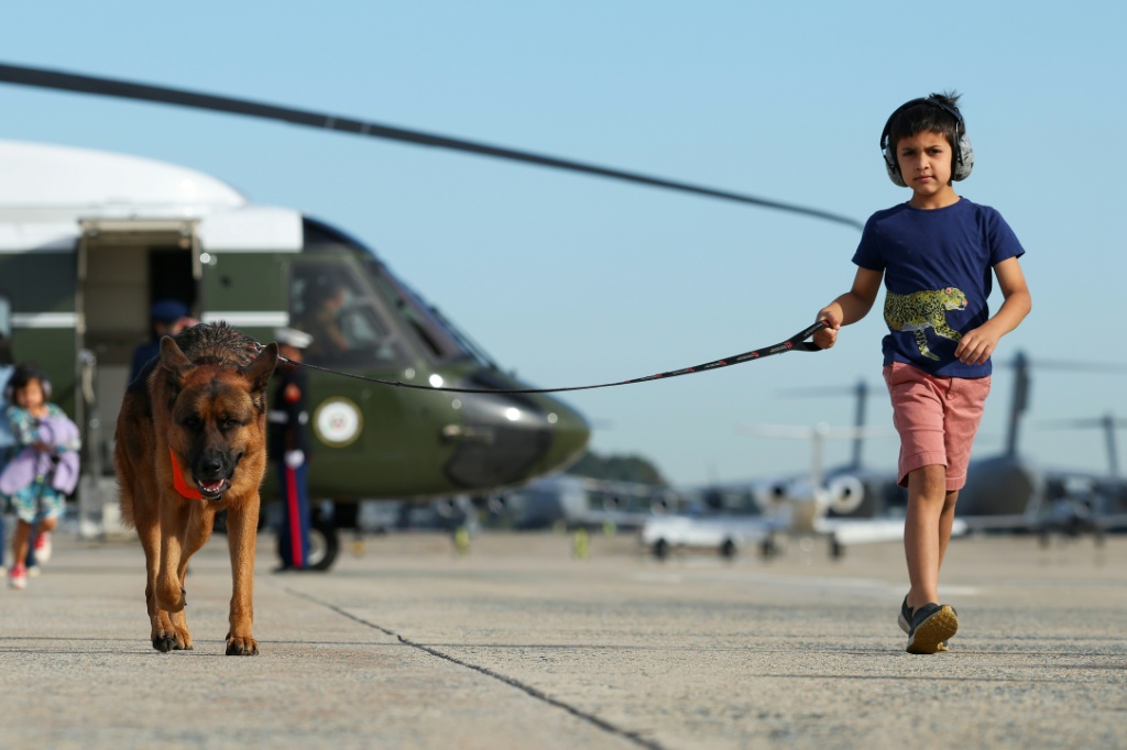 Vivek Vance, son of US Vice President JD Vance, runs with dog Atlas to board Air Force Two — Samuel Corum / AFP