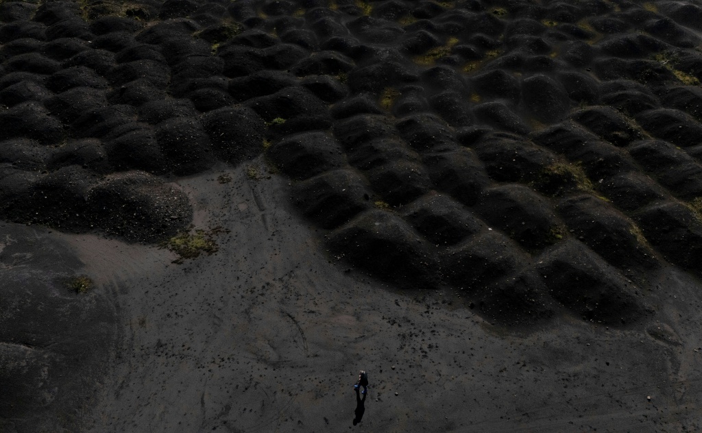 Lunar landscape: a man walks by the huge waste dump around Elbasan's steelworks complex — Adnan Beci / AFP