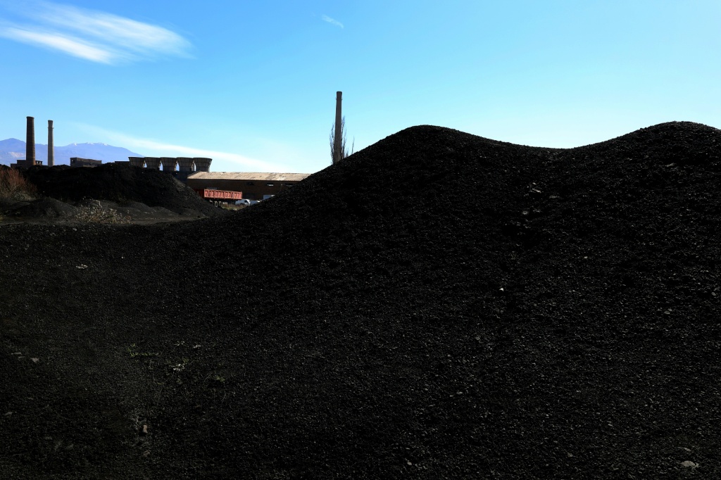 Hills of soot-black waste dot the landscape around the Elbasan steelworks complex — Adnan Beci / AFP