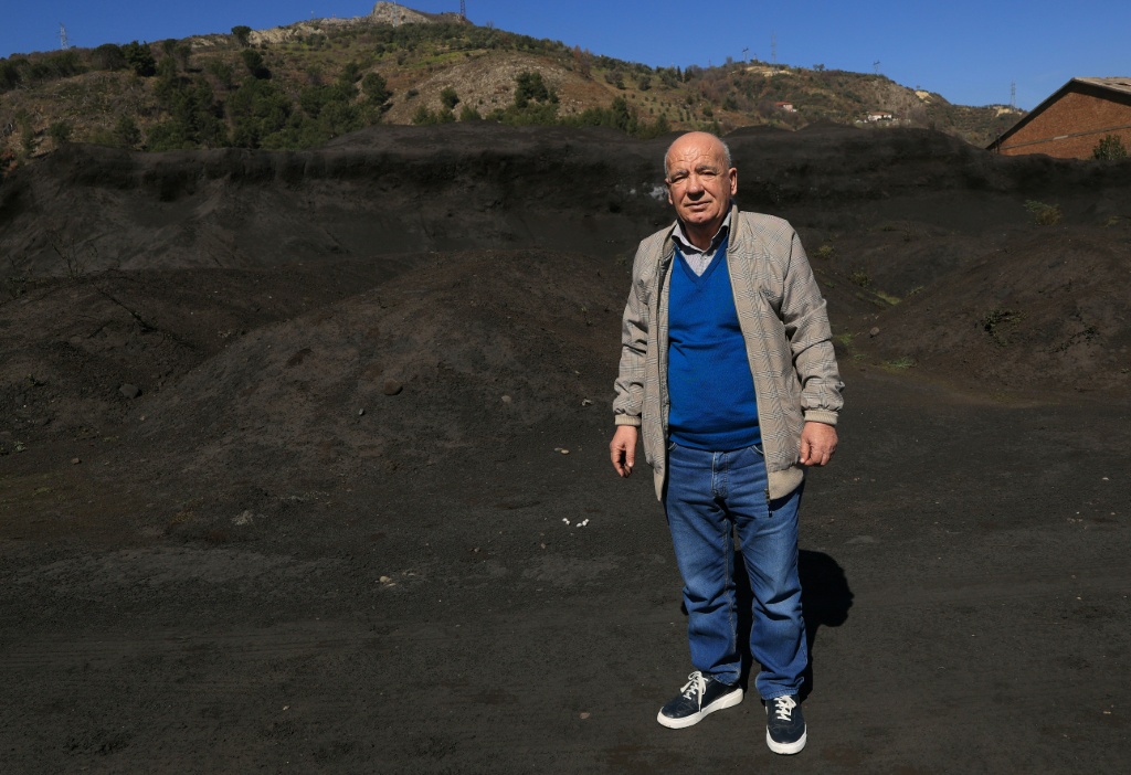 Environmental expert Beqir Kila walks through an open-air waste dump from the Elbasan steel plants — Adnan Beci / AFP
