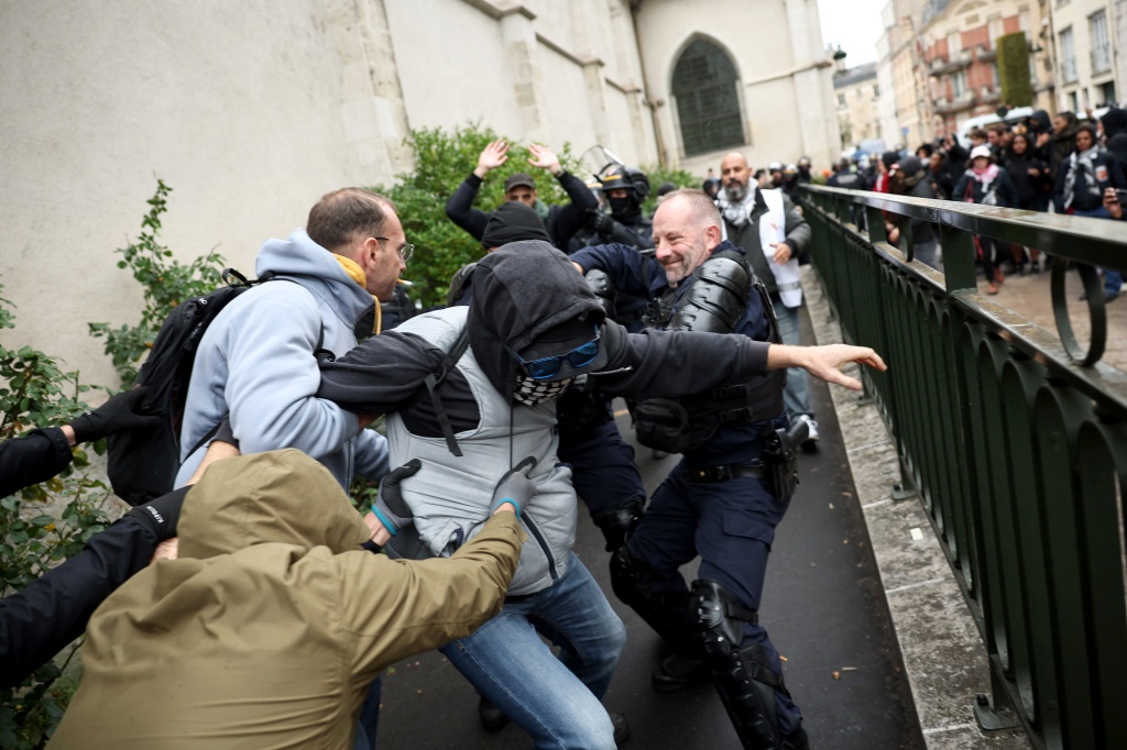Police attempt to arrest a counter-protester against a congress by far-right leader Marine Le Pen's party — SIMON WOHLFAHRT / AFP