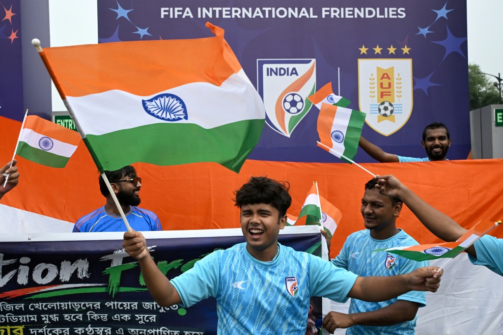 Fans wave India's national flag near the Salt Lake Stadium in Kolkata on October 3, 2026, before the start of the international friendly football match between India and Brazil. — Dibyangshu SARKAR / AFP