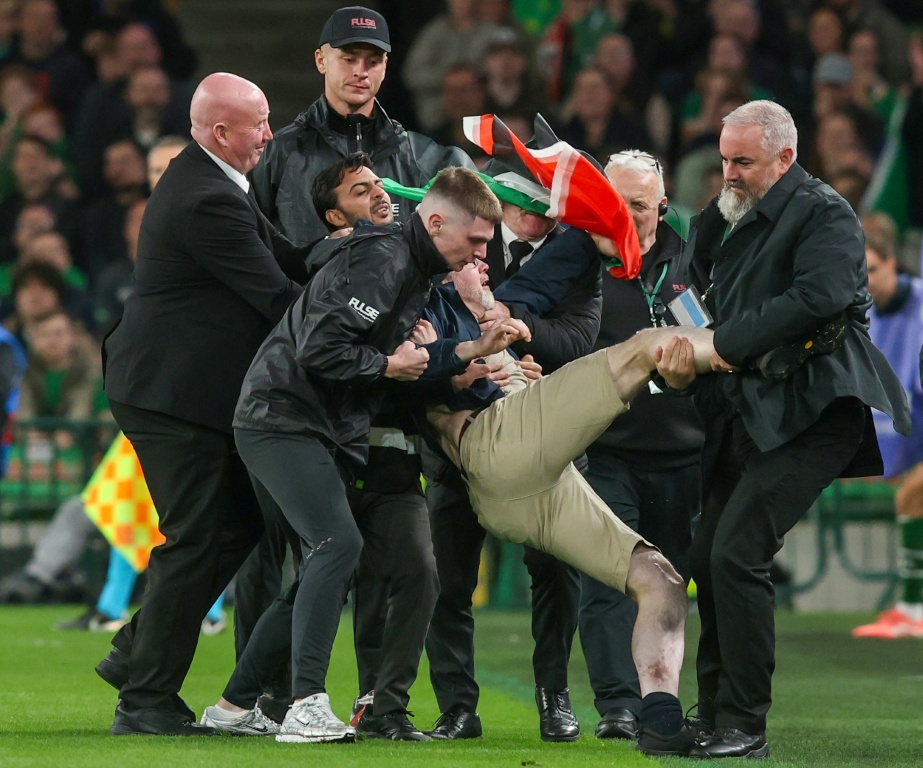 A pitch invader is carried away after interrupting Ireland's game against Austria — Paul Faith / AFP
