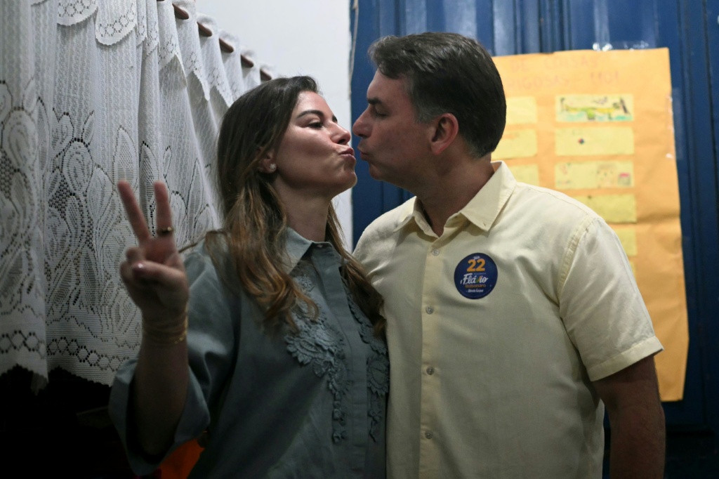 Flavio Bolsonaro and his wife, Fernanda, on the day of the runof election — MAURO PIMENTEL / AFP
