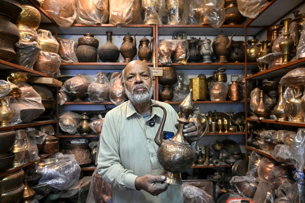 Antique dealer Ahsan Shakeel shows an artefact at his shop selling vintage items in Rawalpindi — Farooq NAEEM / AFP
