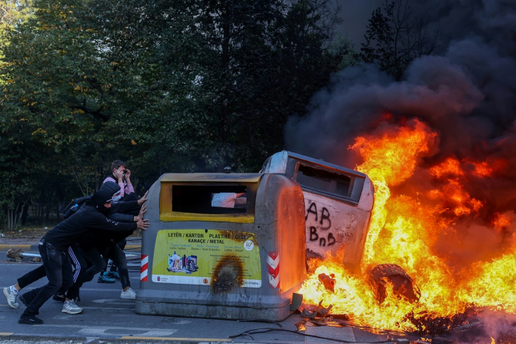 Some of the protesters set objects on fire — Adnan Beci / AFP