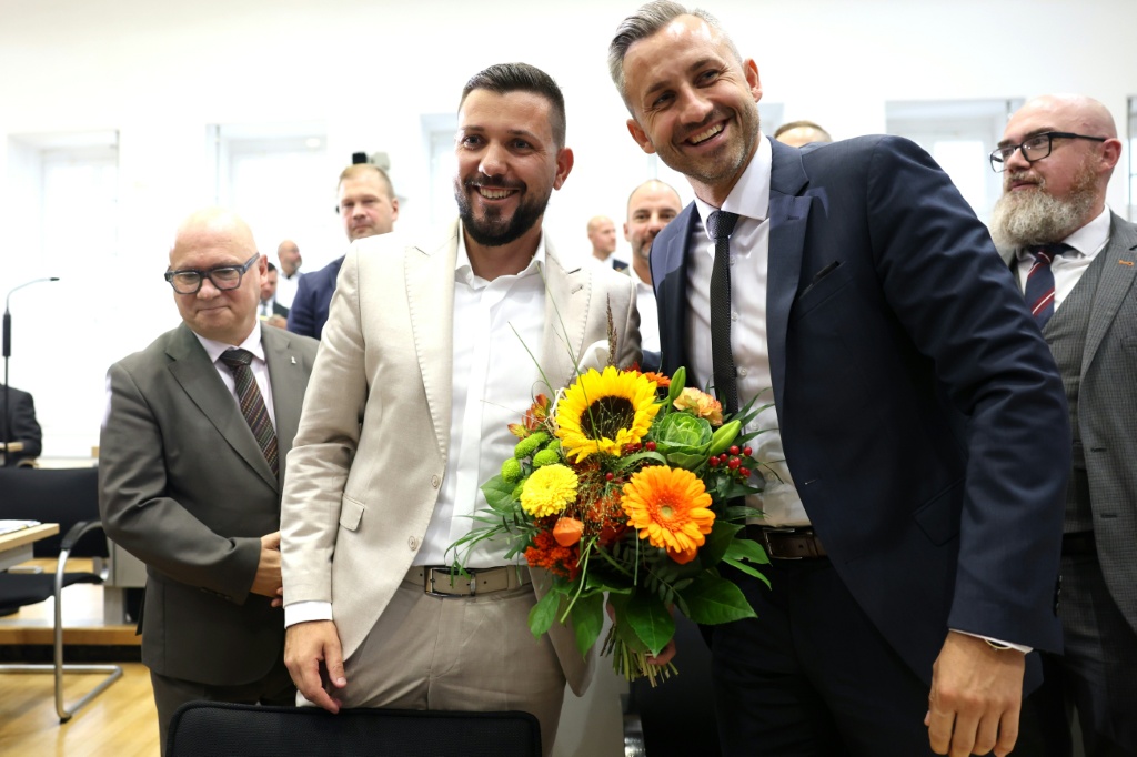 Ulrich Siegmund of the far-right Alternative for Germany (AfD) party gives flowers to congratulate AFD's Tobias Rausch (centre) on his election as president of the state parliament in Saxony-Anhalt — Jan Woitas / AFP