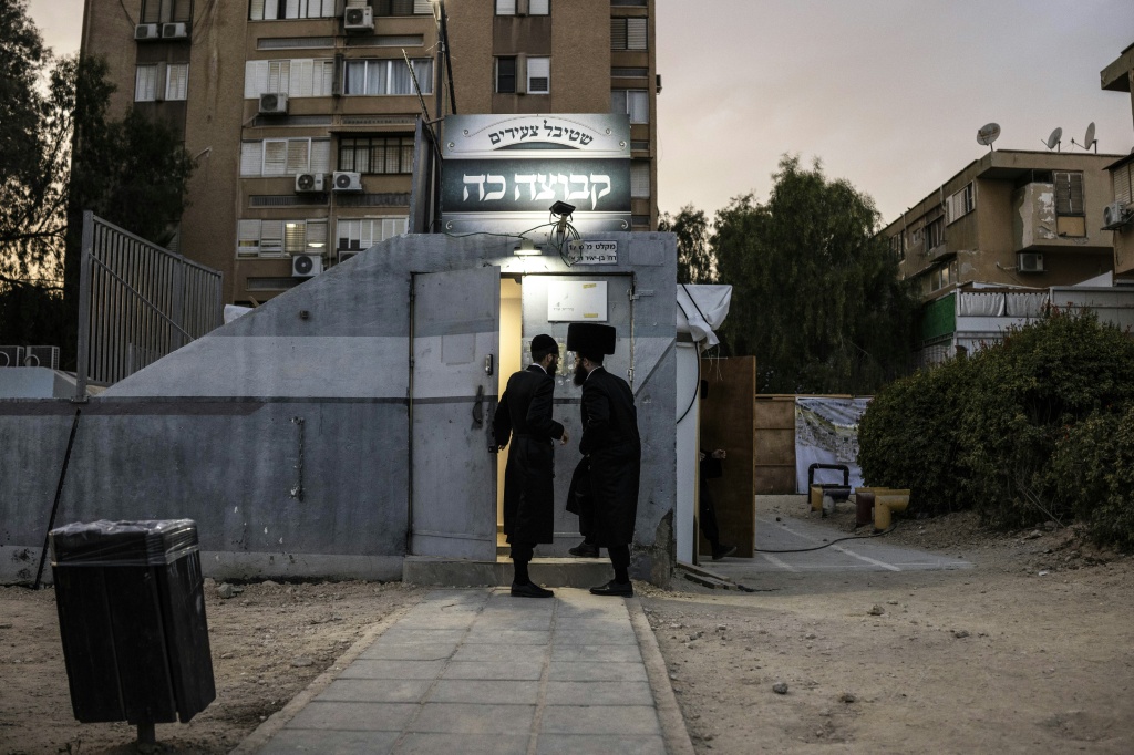 Ultra-Orthodox Jewish men walk into an underground shelter used as a prayer hall in Arad on October 1, 2026. Some secular residents have complained that some rocket shelters have been turned into prayer rooms, reducing their availability during emergencies. — JOHN WESSELS / AFP