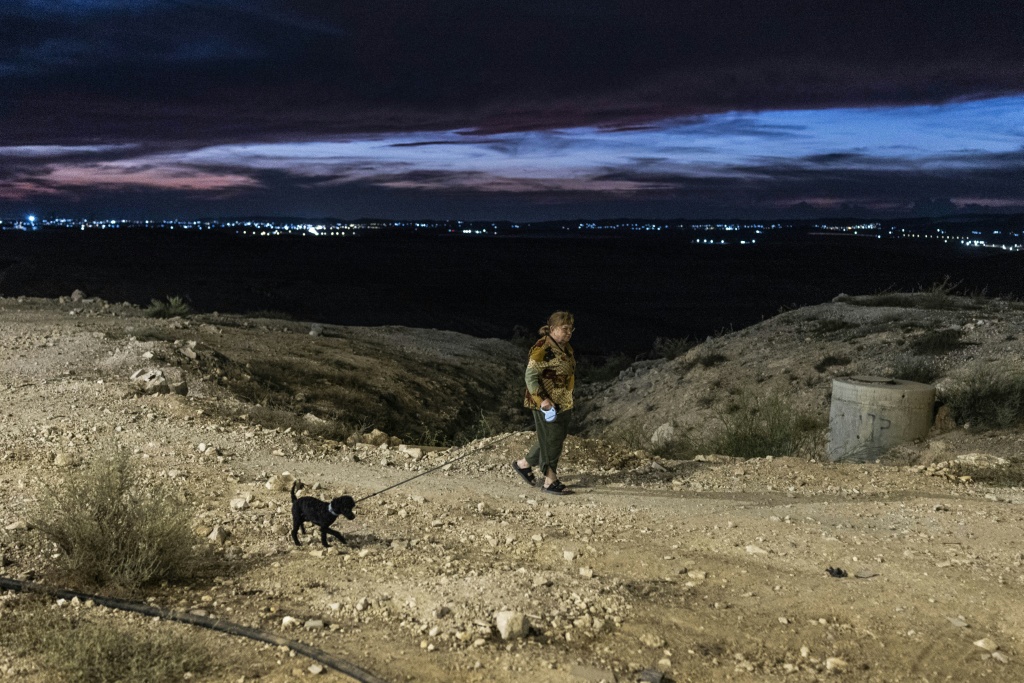 A woman walks her dog on the outskirts of Arad on October 1, 2026. Some secular residents acknowledge that day-to-day coexistence with the ultra-Orthodox population is generally peaceful. — JOHN WESSELS / AFP