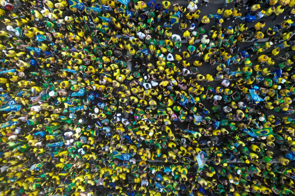 Ahead of the debate, thousands of supporters of Flavio Bolsonaro gathered for a campaign rally along Sao Paulo's Paulista Avenue, dressed in the yellow and green of the Brazilian flag — Miguel SCHINCARIOL / AFP