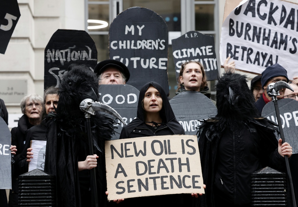 Demonstrators hold placards as they demonstrate in London against approval for drilling at the Jackdaw site for oil and gas in the North Sea — Brook Mitchell / AFP