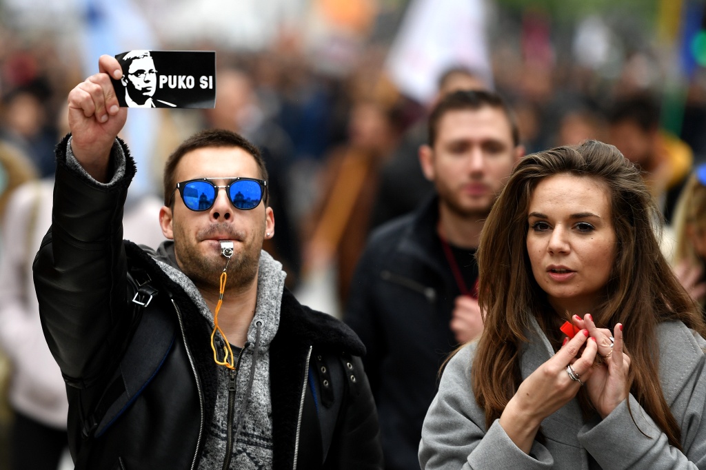 A protester holds a sticker, showing Serbian Prime Minister Aleksandar Vucic and reading 'You are finished' — ANDREJ ISAKOVIC / AFP