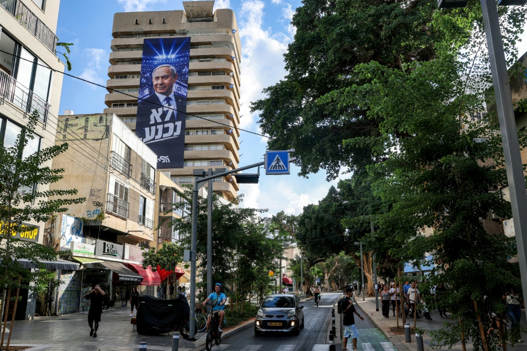 A giant electoral poster for Israeli Prime Minister Benjamin Netanyahu's Likud party with the slogan "no surrender" on the facade of a building in Tel Aviv — Jack GUEZ / AFP