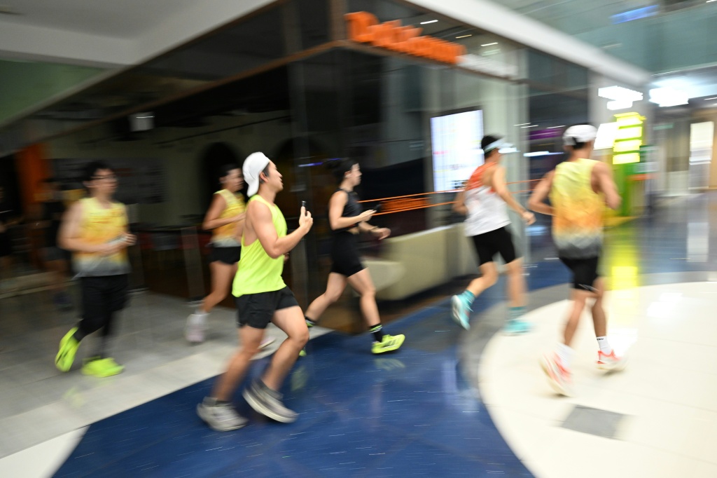 The pounding of running shoes echoes through a Singapore shopping mall — Roslan RAHMAN / AFP
