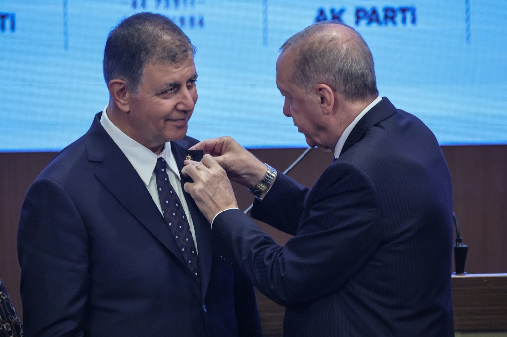 President Recep Tayyip Erdogan personally welcomed Izmir Mayor Cemil Tugay into the party, pinning a badge onto his lapel — Adem ALTAN / AFP