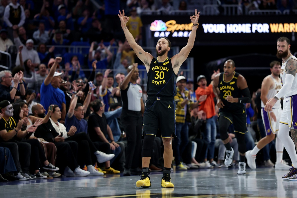 Golden State star Stephen Curry celebrates teammate Al Horford's basket in the Warriors' NBA Cup victory over the Los Angeles Lakers — EZRA SHAW