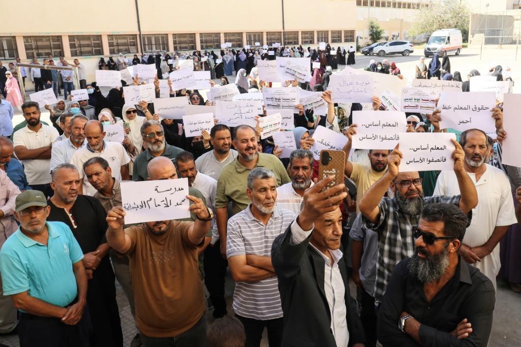 Teachers hold up placards during a demonstration demanding higher salaries and better working conditions at a school in Tripoli on September 29, 2026. — Mahmud Turkia / AFP