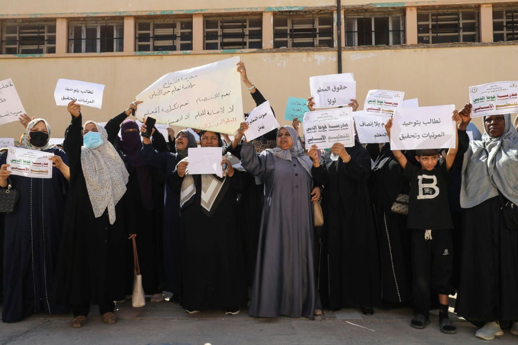 Teachers hold up placards during a demonstration demanding higher salaries and better working conditions at a school in Tripoli on September 29, 2026. — Mahmud Turkia / AFP