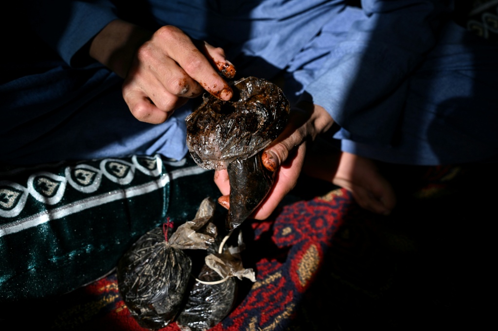 An Afghan farmer holds raw opium at his house in Badakhshan province — STR / AFP