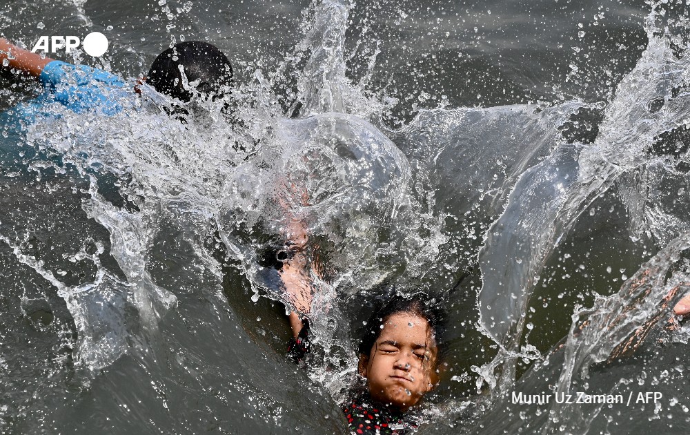Children swim in the Buriganga River in Dhaka