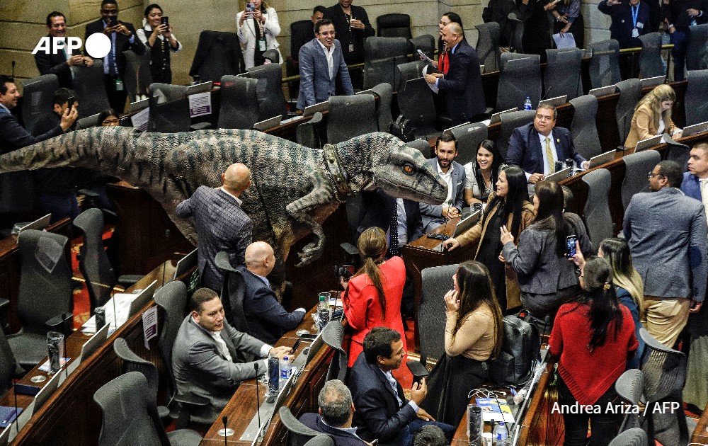 A person in a dinosaur costume makes an appearance at the Colombia Congress during a debate on climate change