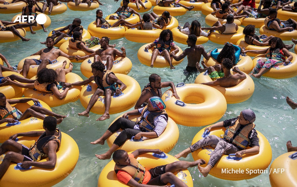 People play with inflatable donuts at a water park