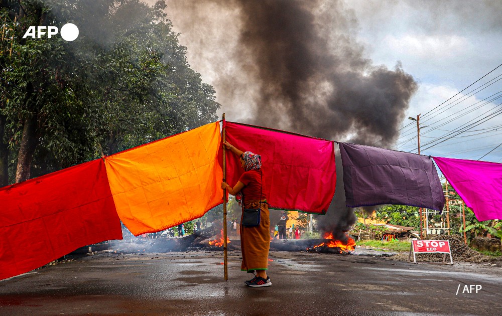 A woman blocks a road during general strike