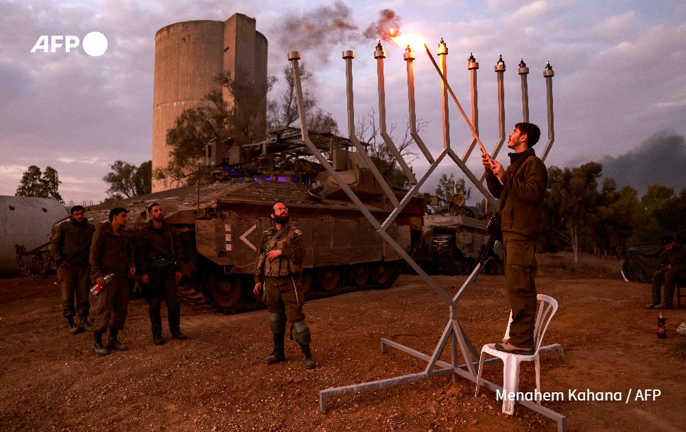 Israeli soldier lights the sixth candle of the sixth day of the Jewish Hanukkah holiday