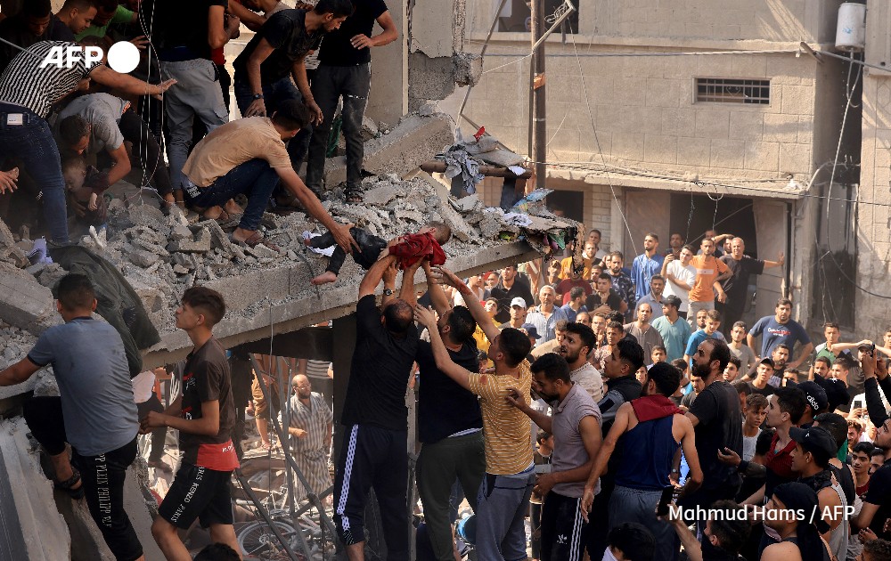 Des sauveteurs tirent un enfant des décombres d’un bâtiment touché par une frappe israélienne à Khan Yunis, dans le sud de la bande de Gaza, le 24 octobre 2023