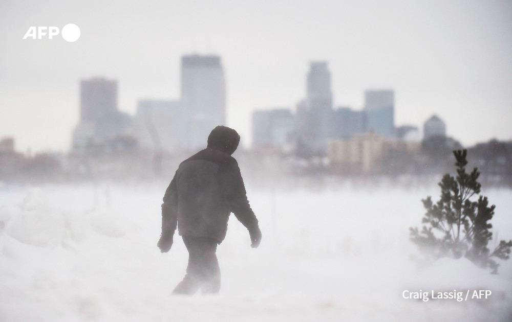 man walks during snowstorm, Minneapolis, United States.