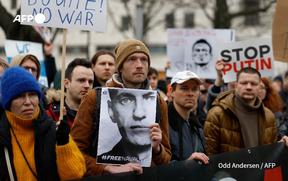 A man holds a photo of Alexei Navaln at a rally