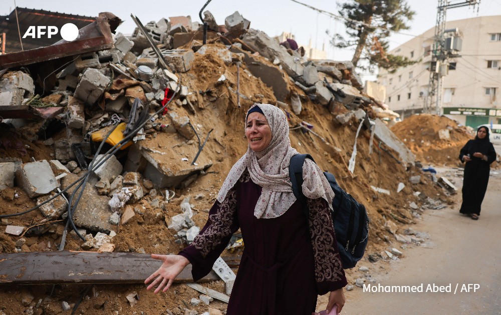 Woman reacts next to the rubble of a building following Israeli strikes
