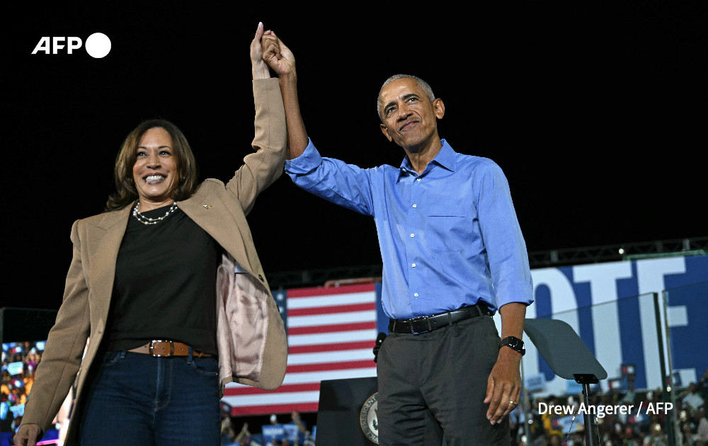 Former US President Barack Obama holds hands with US Vice President and Democratic presidential candidate Kamala Harris during a campaign rally at the James R Hallford Stadium in Clarkston, Georgia on October 24, 2024.